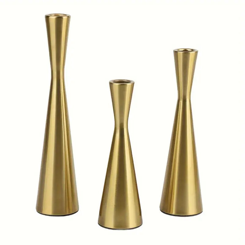 Three gold metal vases of varying heights on a white background