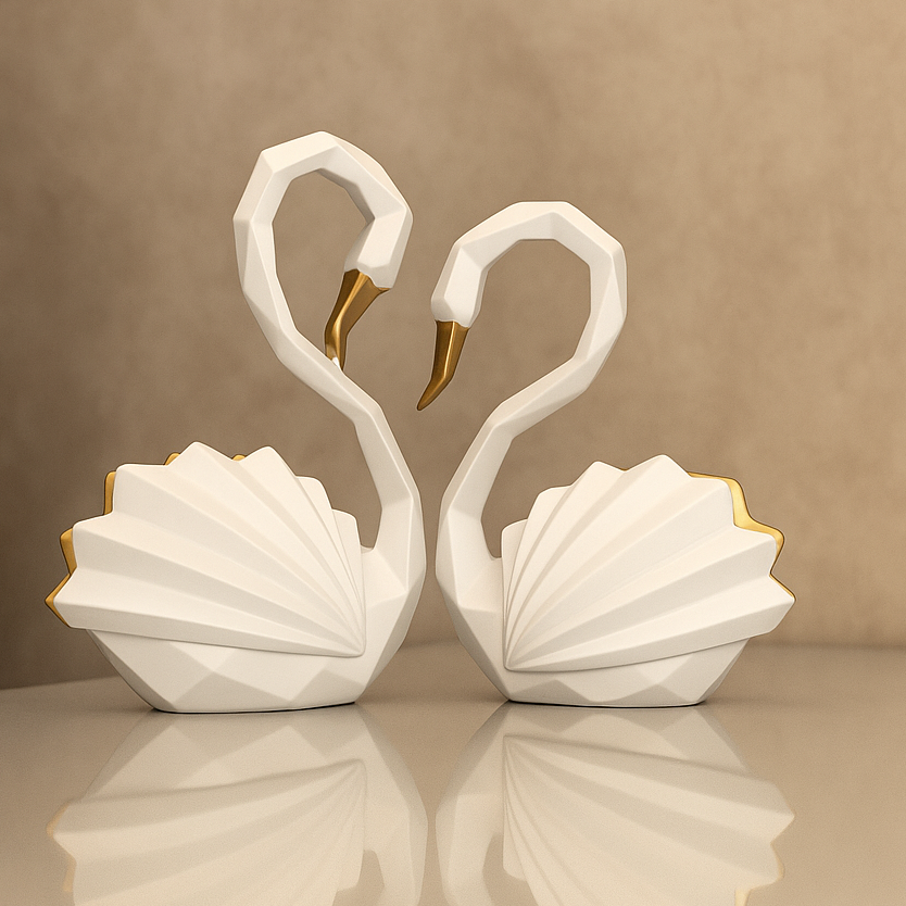 Two white swan sculptures with gold accents on a reflective surface and beige background