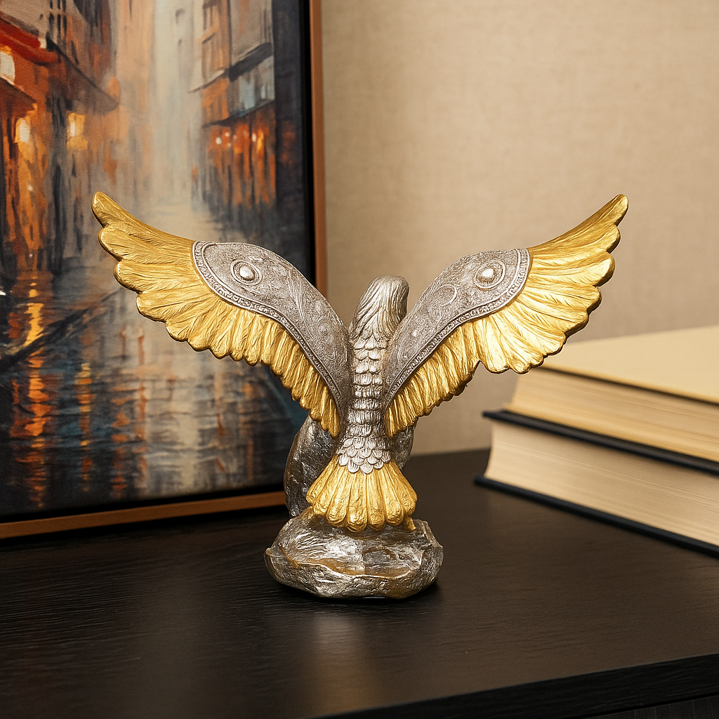 Decorative eagle statue with gold and silver wings on a wooden surface.