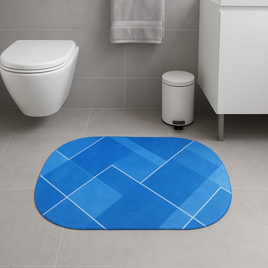 Blue geometric-patterned bath mat on a bathroom floor with a toilet and trash can in the background.