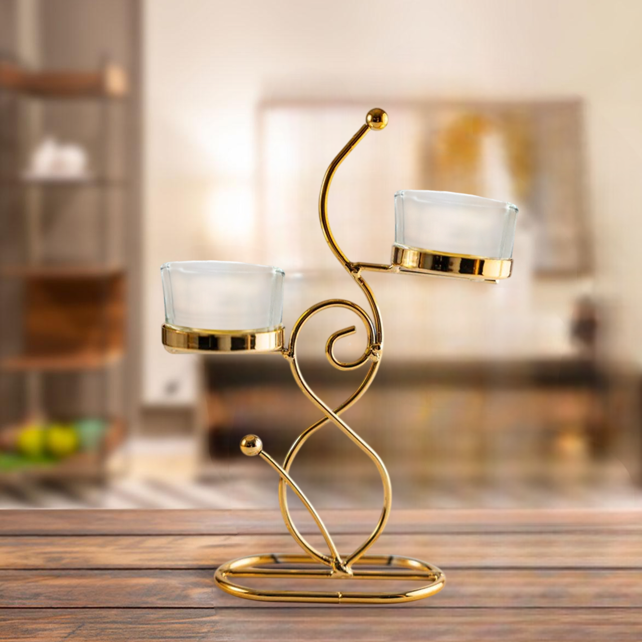 Gold candle holder with two glass candle holders on a wooden surface.