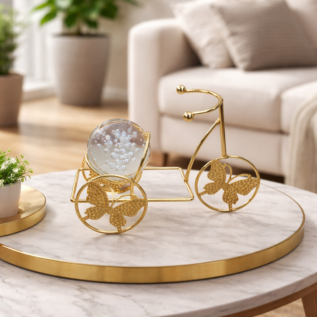 Decorative gold bicycle on a marble table with a blurred living room background