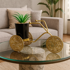 Decorative gold tricycle with a plant on a glass coffee table in a living room.