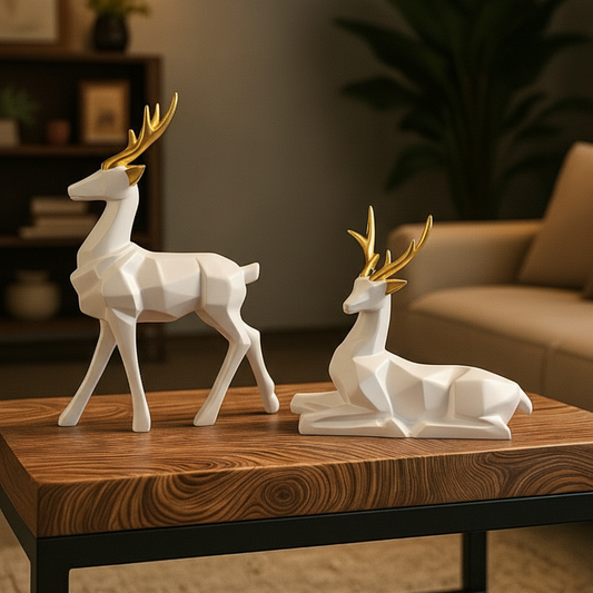 Two white deer figurines with gold antlers on a wooden table in a living room setting.