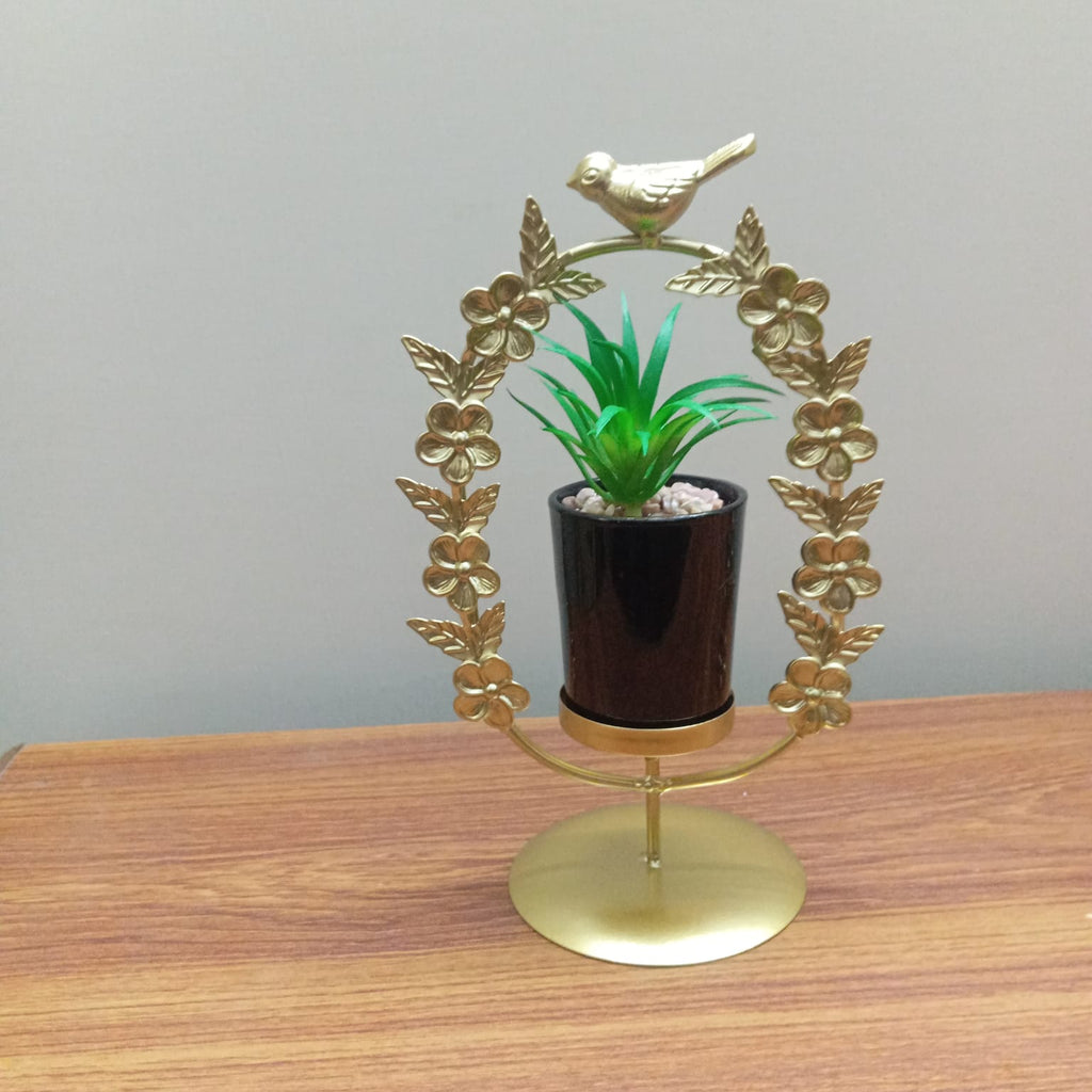 Decorative gold stand with a potted plant on a wooden surface