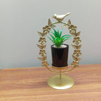 Decorative gold stand with a potted plant on a wooden surface