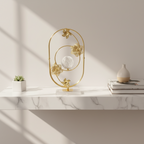 Decorative gold metal sculpture with floral designs on a wooden surface