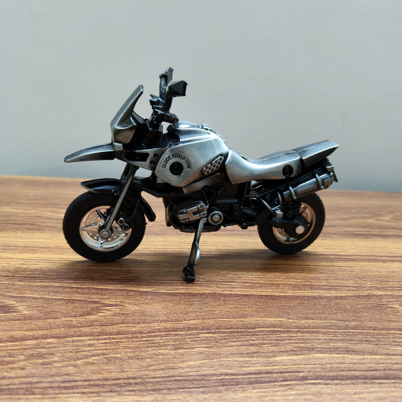 Model motorcycle on a wooden surface with a neutral background