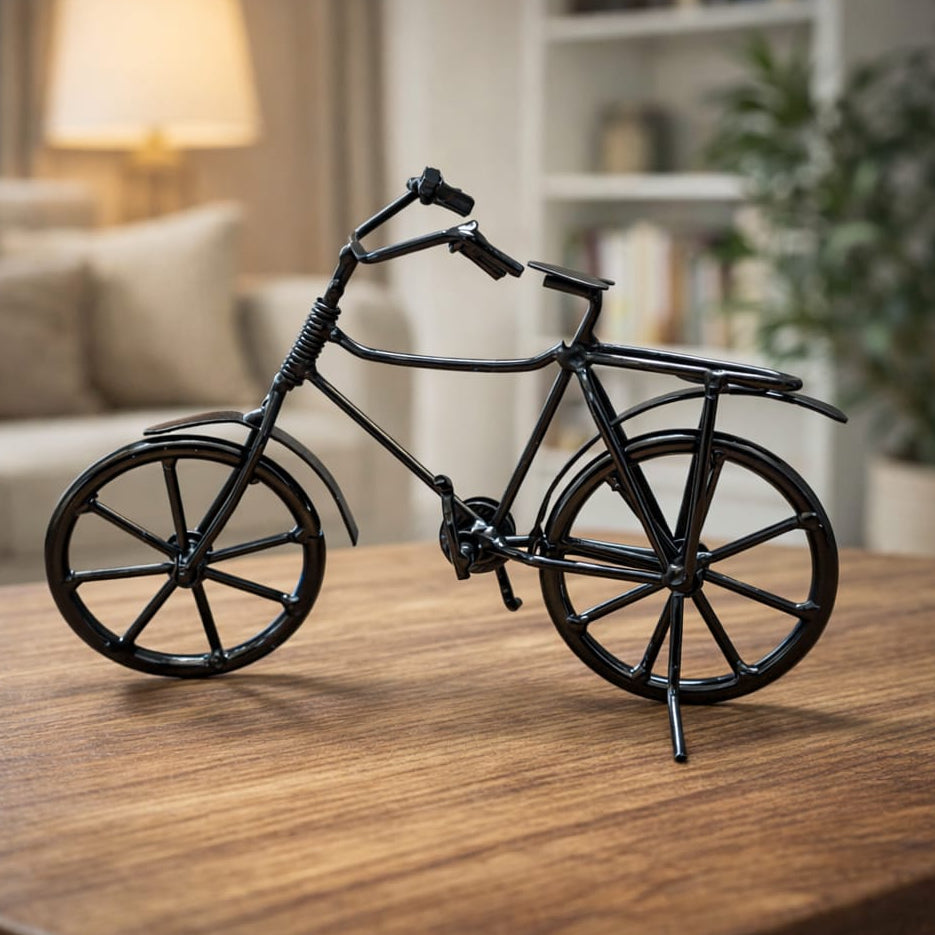 Black bicycle model on a wooden table in a cozy living room setting