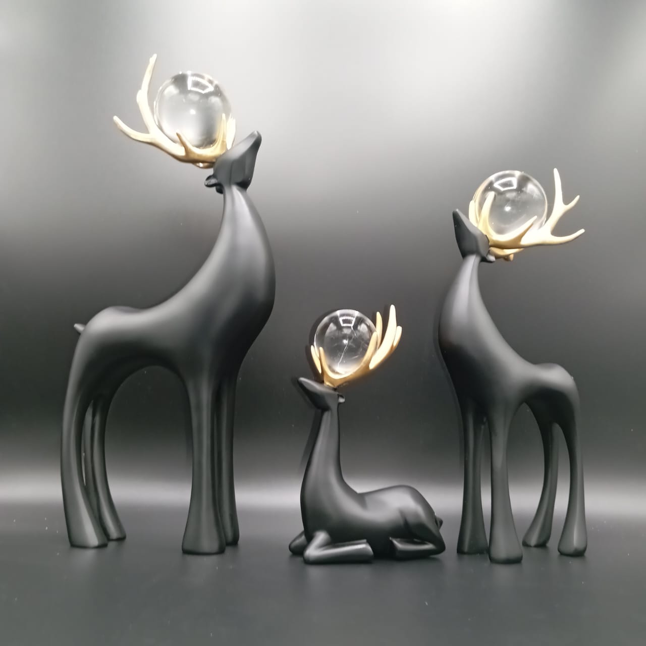 Artistic deer decor set featuring three elegantly designed deer figures with glass orbs on their antlers.