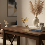 Decorative gold lotus sculpture on a wooden table with books and a vase.